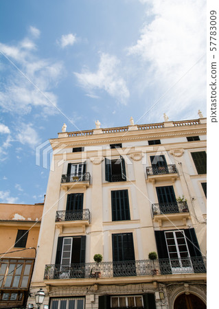 Mallorca cityscape Light cream building with windows with scarlet light shade doors 57783009