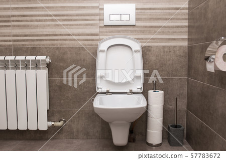 New white ceramic toilet on a gray tile background. The interior of the restroom. 57783672
