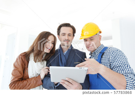 Worker and couple look at tablet Worker and couple look at tablet 57783868
