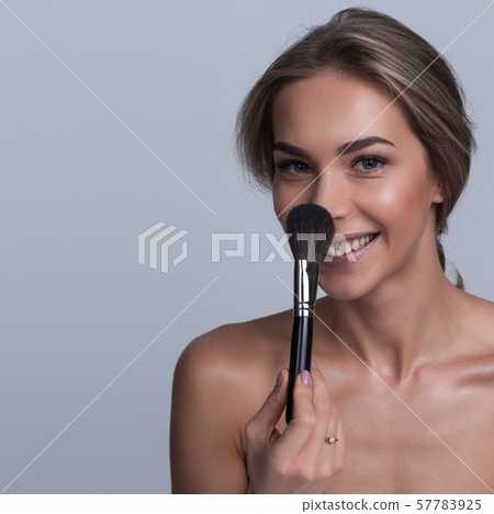 Woman holding makeup brush 57783925