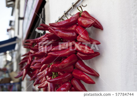 Red peppers hanging at the front of a grocery 57784744