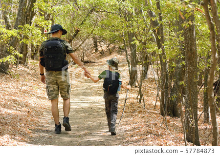 Father and son walking in forest 57784873