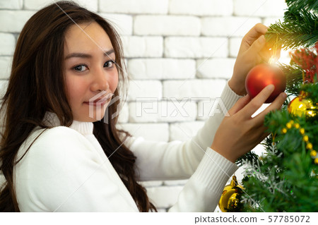 girl decorating Christmas tree girl decorating Christmas tree 57785072