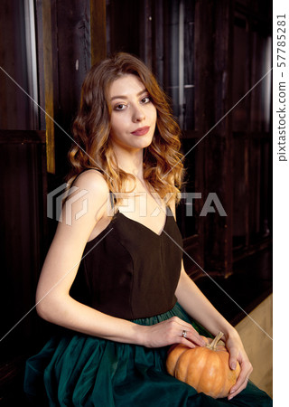 Holidays, halloween, decoration and people concept - close-up of woman with pumpkins at home 57785281