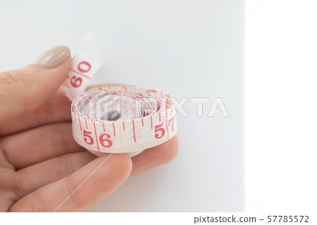 Woman hold soft body measuring tape with 57785572
