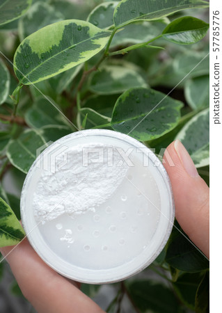 Opened box with mineral powder in female hand on 57785776