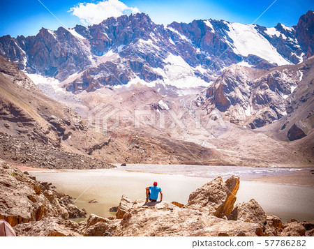 Hiker near Lake Moutniy on rocky mountain background. Fann Mountains, Tajikistan, Central Asia Hiker near Lake Moutniy on rocky mountain background. Fann Mountains, Tajikistan, Central Asia 57786282