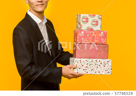 Handsome asian businessman holding gift box over 57786529