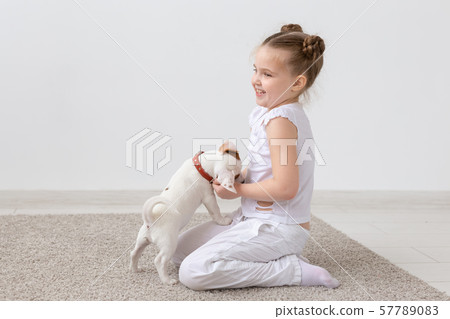 Pets and animal concept - Child girl playing with puppy Jack Russell Terrier Pets and animal concept - Child girl playing with puppy Jack Russell Terrier 57789083