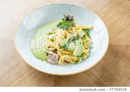 Italian pasta tagliatelle with zucchini, Turkey and green sauce. Parmesan cheese Italian pasta tagliatelle with zucchini, Turkey and green sauce. Parmesan cheese 57789536