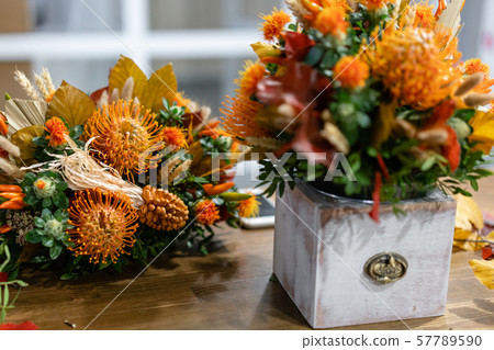 Autumn bouquet of mixed flowers on wooden table. The work of the florist at a flower shop. Fresh cut Autumn bouquet of mixed flowers on wooden table. The work of the florist at a flower shop. Fresh cut 57789590