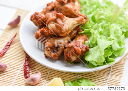 Fried chicken wings on white plate with garlic Fried chicken wings on white plate with garlic 57789673