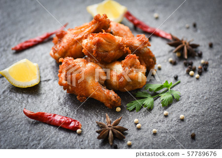 Fried chicken wings on black plate with lemon Fried chicken wings on black plate with lemon 57789676
