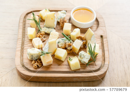 Cheese plate. Delicious cheese mix with walnuts, honey on wooden table. Tasting dish on a wooden Cheese plate. Delicious cheese mix with walnuts, honey on wooden table. Tasting dish on a wooden 57789679