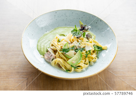 Italian pasta tagliatelle with zucchini, Turkey and green sauce. Parmesan cheese Italian pasta tagliatelle with zucchini, Turkey and green sauce. Parmesan cheese 57789746