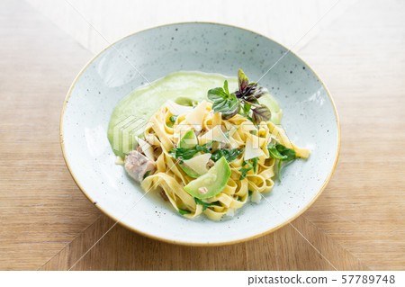 Italian pasta tagliatelle with zucchini, Turkey and green sauce. Parmesan cheese 57789748