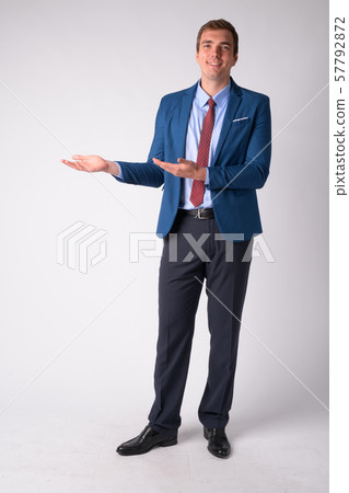 Full body shot of happy businessman in suit showing something 57792872