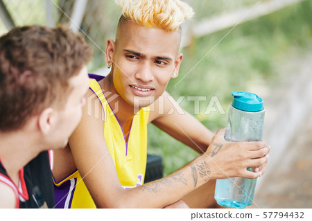 Young basketball player listening to his teammate Young basketball player listening to his teammate 57794432