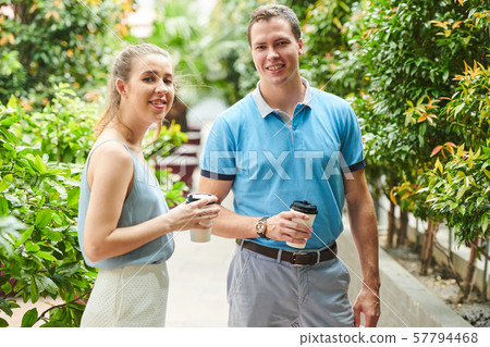 Smiling coworkers drinking coffee outdoors Smiling coworkers drinking coffee outdoors 57794468