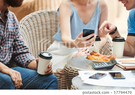 Business people discussing picture on smartphone screen Business people discussing picture on smartphone screen 57794470