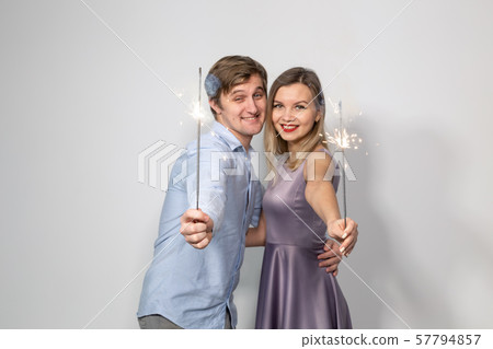 Party, fun, new year 2020, christmas and holidays concept - young happy couple with sparklers on 57794857