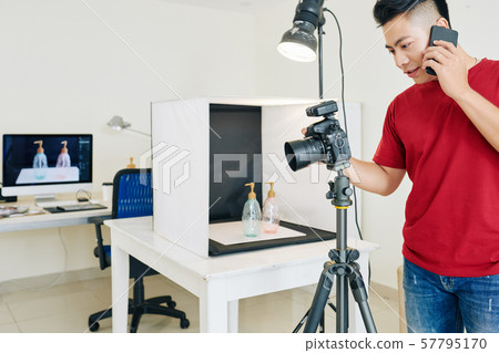 Photographer setting up digital camera Photographer setting up digital camera 57795170