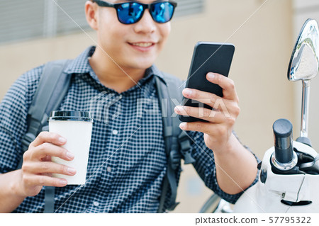 Positive man reading text messages Positive man reading text messages 57795322