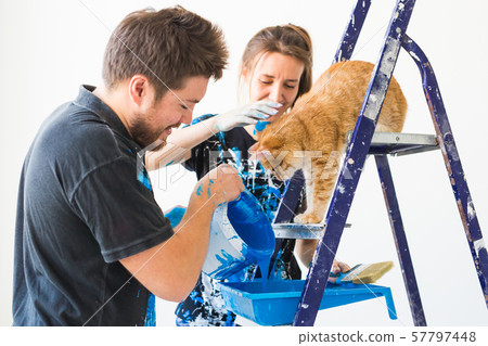 People, redecoration and renovation concept - portrait of couple with cat pour paint People, redecoration and renovation concept - portrait of couple with cat pour paint 57797448