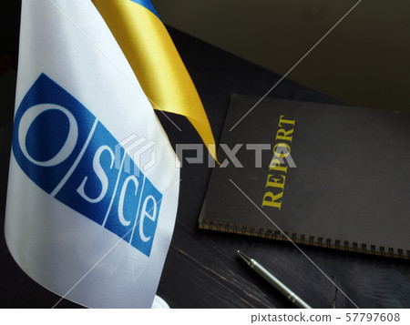 OSCE and Ukrainian flags with report on the desk. OSCE and Ukrainian flags with report on the desk. 57797608