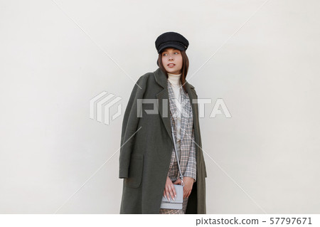 Fashionable woman with a hat in a stylish green coat Fashionable woman with a hat in a stylish green coat 57797671