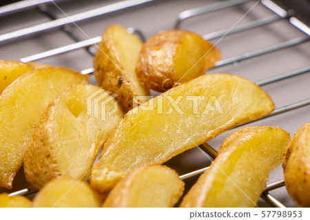 Fresh fried potatoes (with skin and natural cut) placed on a fried bat. Fresh fried potatoes (with skin and natural cut) placed on a fried bat. 57798953