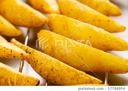 Fresh fried potatoes (with skin and natural cut) placed on a fried bat. Fresh fried potatoes (with skin and natural cut) placed on a fried bat. 57798954