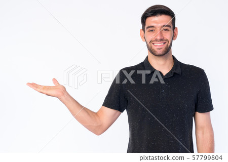 Portrait of happy young bearded Persian man showing something 57799804