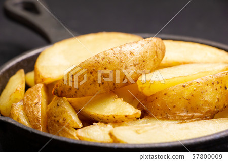 Up of fried potatoes (with skin and natural cut) in skillet. 57800009