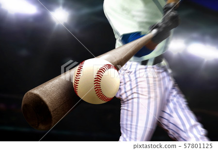 Baseball player hitting ball with bat in close up Baseball player hitting ball with bat in close up 57801125