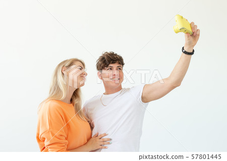Funny crazy young couple blonde girl and a hipster guy taking a selfie on a vintage yellow film 57801445
