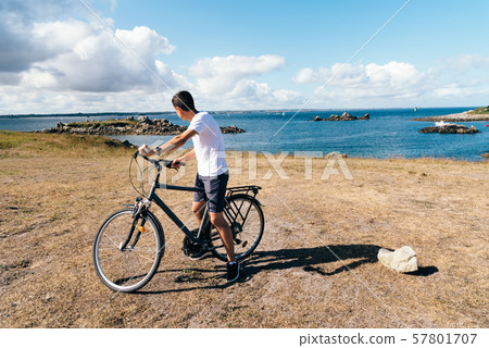 Attractive young male riding bicycle in the Island of Batz Attractive young male riding bicycle in the Island of Batz 57801707