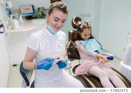 Dentist show to little girl how to wash teeth Dentist show to little girl how to wash teeth 57802473