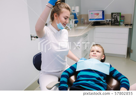 Young boy sitting on the dental chair at the office. Children's dentist examination baby teeth Young boy sitting on the dental chair at the office. Children's dentist examination baby teeth 57802855