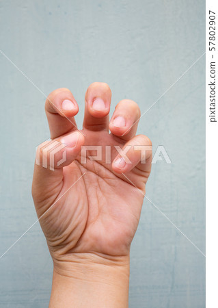 Trigger Finger lock on fingers of woman's front left hand, Suffering from pain, On Blue-grey colour background, Close up & Macro shot, Office syndrome, Health care concept Trigger Finger lock on fingers of woman's front left hand, Suffering from pain, On Blue-grey colour background, Close up & Macro shot, Office syndrome, Health care concept 57802907