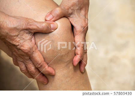 Senior woman suffering from knee pain sitting on chair, Massaging by her hand, Close up, Body concept 57803430