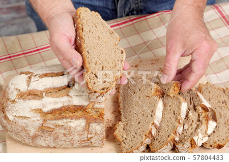 man hands with fresh bread on wood table 57804483