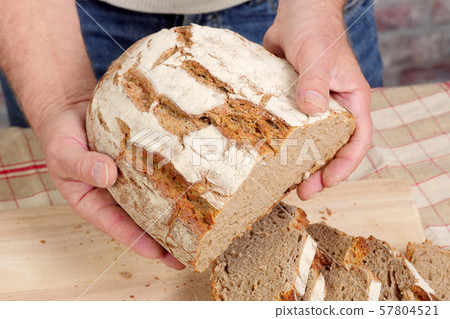 man hands with fresh bread on wood table 57804521
