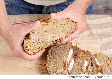 man hands with fresh bread on wood table 57804523