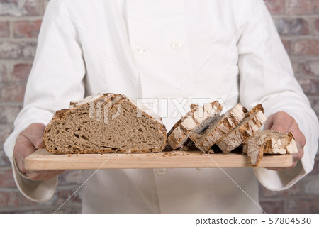 Baker hands with fresh bread on wood table 57804530