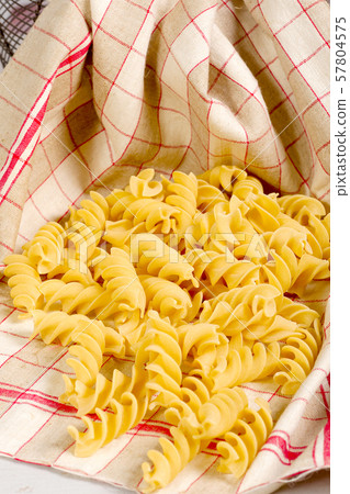 Pasta in a towel on a wooden table 57804575