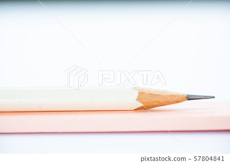 A white pencil on pink and white notebook on white background, Close up & Macro shot, Selective focus, Stationery concept A white pencil on pink and white notebook on white background, Close up & Macro shot, Selective focus, Stationery concept 57804841