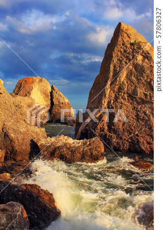 Waves crash against rocks in the sea 57806327