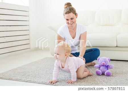 Mother is playing with little baby. Happy woman with her daughter 57807811