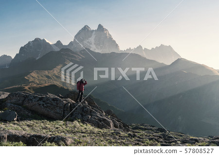 Mountaineer with backpack on rock Mountaineer with backpack on rock 57808527